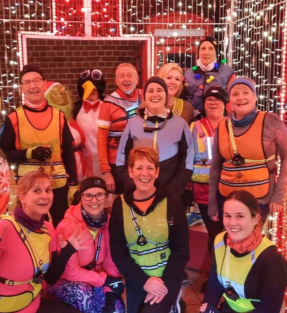 A mixed group of runners in high viz at night