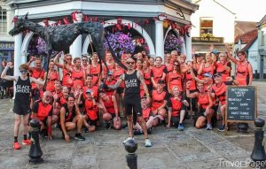 Members of Bungay Black Dog Running Club at the Buttercross in Bungay with the large black shuck effigy. Taken at the Black Shuck Run 2025